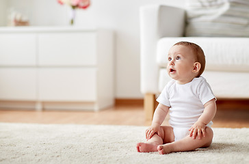 Image showing happy baby boy or girl sitting on floor at home