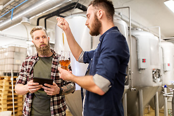Image showing men with pipette testing craft beer at brewery