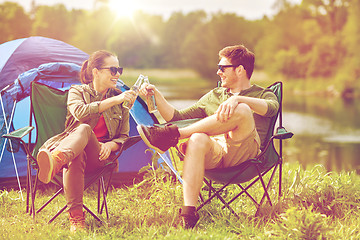 Image showing happy couple clinking drinks at campsite tent