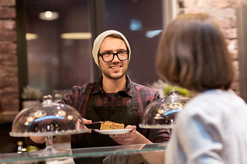 Image showing man or barman with cakes serving customer at cafe