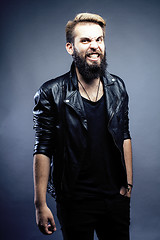 Image showing portrait of young bearded hipster guy smiling on gray dark background close up, brutal modern man, lifestyle people concept