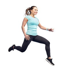 Image showing happy smiling sporty young woman jumping in air