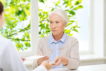 Image showing doctor giving prescription and drug to woman