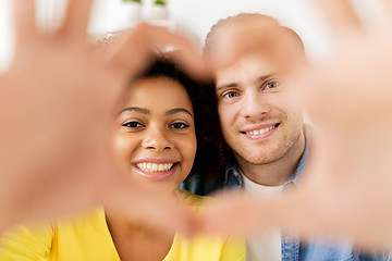 Image showing happy couple looking through heart shape