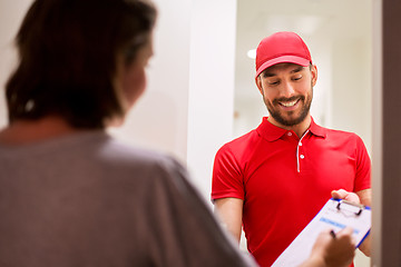 Image showing deliveryman with clipboard at customer home