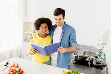 Image showing happy couple with cooking book at home kitchen