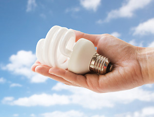 Image showing close up of hand holding energy saving lightbulb