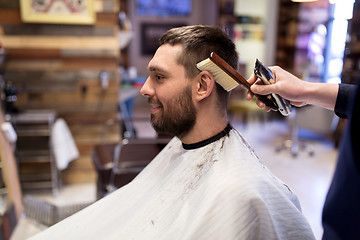 Image showing man and barber with brush cleaning hair at salon