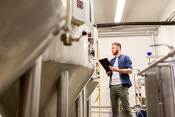 Image showing man with clipboard at craft brewery or beer plant