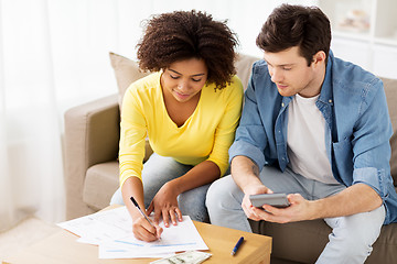 Image showing couple with papers and calculator at home