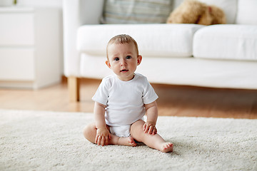 Image showing happy baby boy or girl sitting on floor at home