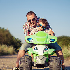 Image showing Father and son playing on the road at the day time.