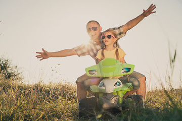 Image showing Father and daughter playing on the road at the day time.