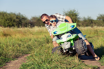 Image showing Father and son playing on the road at the day time.