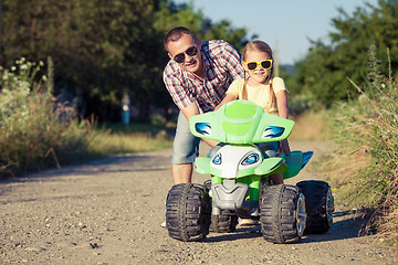 Image showing Father and daughter playing on the road at the day time.
