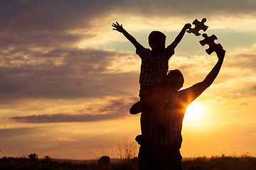 Image showing Father and son playing at the park at the sunset time. 