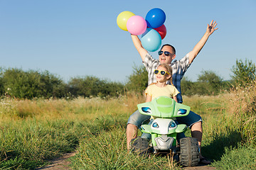 Image showing Father and daughter playing on the road at the day time.