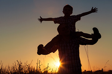 Image showing Father and son playing at the park at the sunset time.