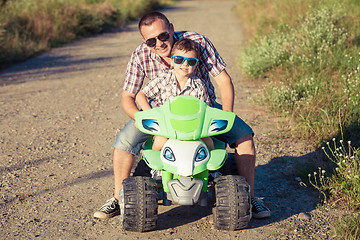 Image showing Father and son playing on the road at the day time. 