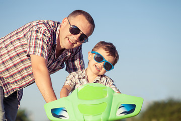 Image showing Father and son playing on the road at the day time.