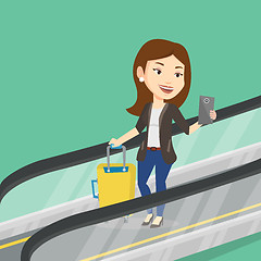 Image showing Woman using smartphone on escalator in airport.