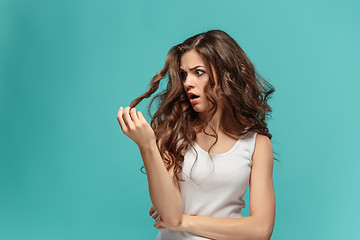 Image showing Frustrated young woman having a bad hair on blue