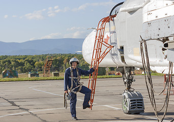 Image showing Military pilot in helmet stands near jet plane