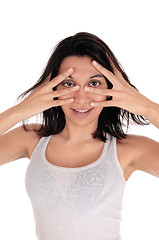 Image showing Young woman looking through her fingers.