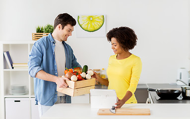 Image showing happy couple with healthy food at home kitchen