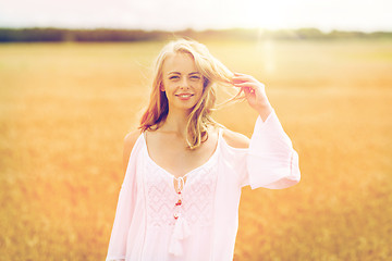 Image showing smiling young woman in white dress on cereal field