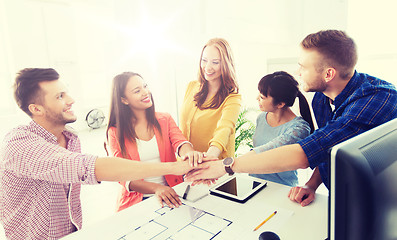 Image showing creative team holding hands together  at office