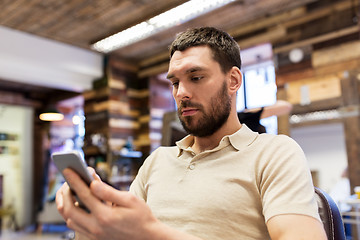 Image showing man with smartphone at barbershop or salon