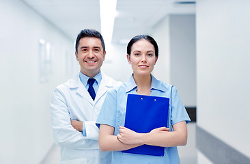 Image showing smiling medics at hospital with clipboard