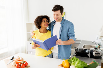 Image showing happy couple with cooking book at home kitchen