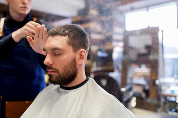 Image showing barber applying styling spray to male hair