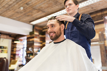 Image showing man and barber styling hair at barbershop