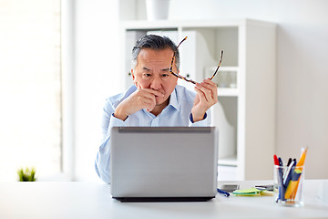 Image showing businessman with eyeglasses and laptop at office