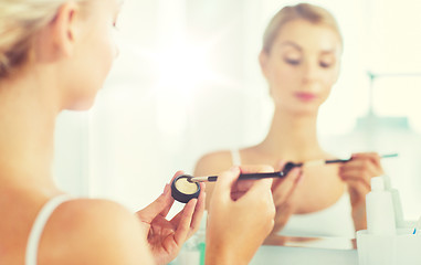 Image showing woman with makeup brush and eyeshade at bathroom