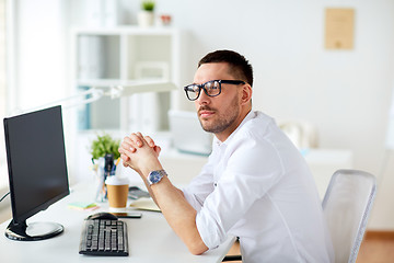 Image showing businessman in glasses sitting at office computer