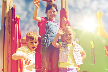 Image showing group of happy kids waving hands on playground