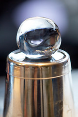 Image showing hand-cut ice ball on top of cocktail shaker at bar