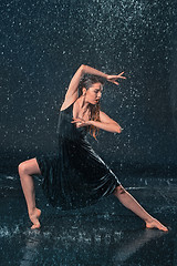 Image showing The young beautiful modern dancer dancing under water drops