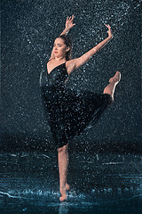 Image showing The young beautiful modern dancer dancing under water drops