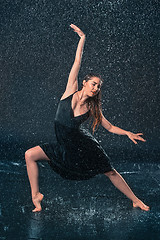 Image showing The young beautiful modern dancer dancing under water drops