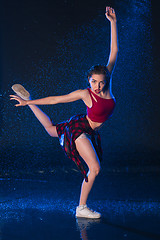 Image showing The young beautiful modern dancer dancing under water drops