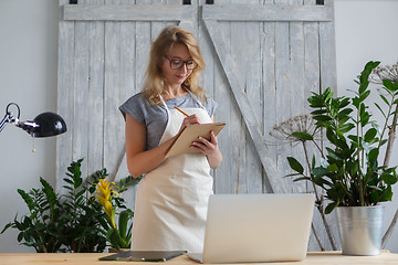 Image showing Girl florist in glasses , apron