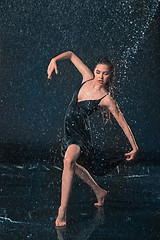 Image showing The young beautiful modern dancer dancing under water drops