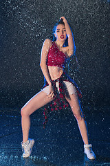 Image showing The young beautiful modern dancer dancing under water drops