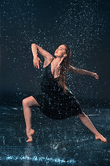 Image showing The young beautiful modern dancer dancing under water drops