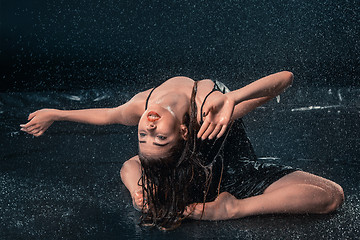 Image showing The young beautiful modern dancer dancing under water drops